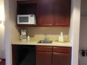 a small kitchen with a sink and a microwave at Ocean 1 Hotel & Suites Ocean City in Ocean City