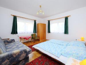 a bedroom with a bed and a couch at Holiday Home Greenie by Interhome in Balatonszárszó
