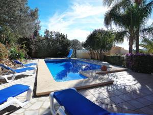 une piscine avec des chaises bleues et une piscine dans l'établissement Villa Aviles by Interhome, à Jávea