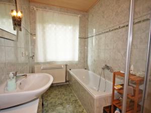 een badkamer met een bad en een wastafel en een ligbad bij Apartment Annemarie by Interhome in Glanz +13 foto's