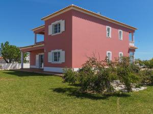 a large red house with a green yard at Villa Casa das Amendoeiras by Interhome in Estevais