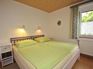 a bedroom with a bed with green sheets and a window at Apartment Annemarie by Interhome in Glanz