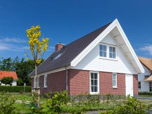 een rood bakstenen huis met een zwart dak bij Holiday Home de Witte Raaf-1 by Interhome in Noordwijkerhout