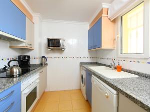 eine Küche mit blauen Schränken und einem Waschbecken in der Unterkunft Apartment Estrella del Mar by Interhome in Denia