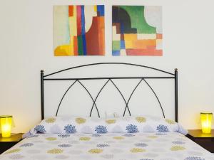 a bed in a bedroom with two lamps and a painting at Holiday Home Pelzer by Interhome in Conil