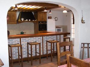 a kitchen with a counter with chairs and a refrigerator at Holiday Home Fromental by Interhome in Bagnac