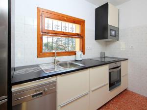 Elle comprend une petite cuisine avec un évier et une fenêtre. dans l'établissement Holiday Home Negrita by Interhome, à Benissa