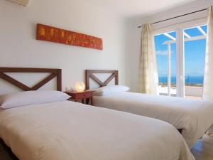 two beds in a room with a view of the ocean at Holiday Home Pelzer by Interhome in Conil