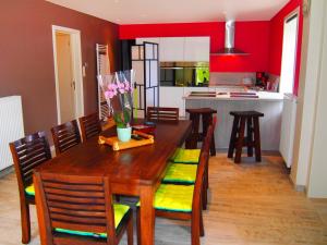 kuchnia i jadalnia z drewnianym stołem i krzesłami w obiekcie Holiday Home Gîte L'Archipel by Interhome w mieście Ellezelles