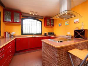 ベグールにあるHoliday Home Estrella by Interhomeの広いキッチン(赤いキャビネット、シンク付)