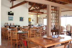 un restaurante con mesas de madera y sillas de madera en Pousada Sítio Pedras de Minas, en Monte Sião
