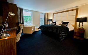 een hotelkamer met een bed en een groot raam bij Hotel Colessio in Stirling