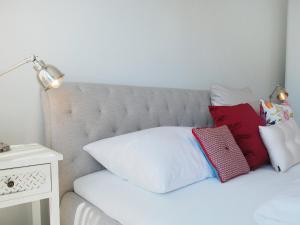 a white bed with red and white pillows on it at Apartment LaVille B-2-3 by Interhome in Locarno