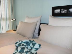 a bed with white pillows and a blanket on it at Apartment LaVille B-3-2 by Interhome in Locarno