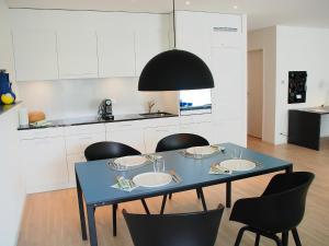 a dining room table with chairs and a black pendant light at Apartment LaVille A-4-3 by Interhome in Locarno