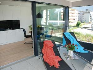 a living room with two chairs and a table with flowers at Apartment LaVille B-2-3 by Interhome in Locarno