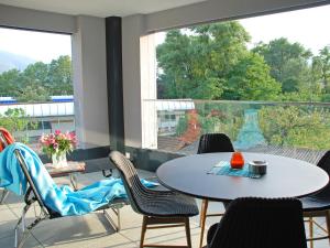 a room with a table and chairs and a large window at Apartment LaVille B-2-3 by Interhome in Locarno