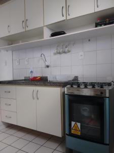 kuchnia z białymi szafkami i piekarnikiem w obiekcie Residence Van Piaget w mieście Fortaleza