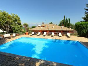 a large blue swimming pool in front of a house at Villa Villa Mina by Interhome in Monte Compatri