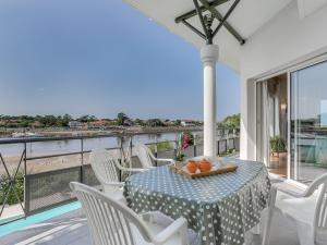 ミミザン・プラージュにあるHoliday Home Les Pinasses by Interhomeの海が見えるバルコニーにテーブルと椅子がある