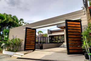 une maison avec des portes en bois devant elle dans l'établissement Addie's Place Soldiers Hills Village Muntinlupa, à Manille
