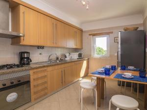 a kitchen with wooden cabinets and a table with chairs at Apartment Valérie by Interhome in Benfarras