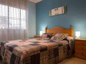 a bedroom with a bed with a blanket and a window at Holiday Home Solimar Cambrils by Interhome in Cambrils