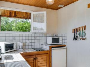 a kitchen with a refrigerator and a microwave at Holiday Home Remember by Interhome in Mimizan-Plage