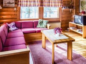 ein Wohnzimmer mit einem lila Sofa und einem Tisch in der Unterkunft Holiday Home Kujalan lomat 1 by Interhome in Nissi