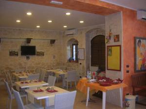ein Restaurant mit Tischen und Stühlen sowie einem TV in der Unterkunft Borgo Rigolizia Vacanze in Rigolizia