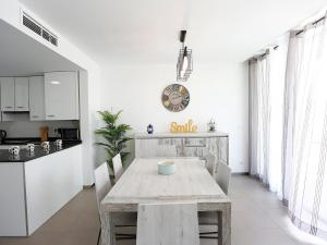 a kitchen and dining room with a table and a clock at Holiday Home Xaloc by Interhome in L'Ampolla