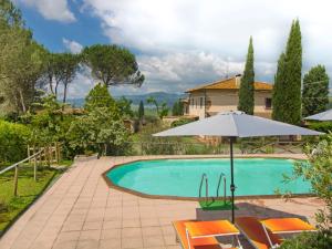ヴォルテッラにあるHoliday Home Villa Etrusca by Interhomeのスイミングプールと傘付きのヴィラ
