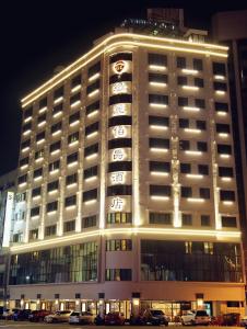 um edifício iluminado com carros estacionados em frente em Grand Earl Hotel em Douliu