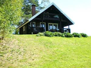 a house sitting on top of a grassy hill at Holiday Home 6144 by Interhome in Jäniskylä