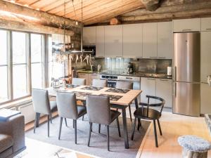 une cuisine avec une table, des chaises et un réfrigérateur dans l'établissement Holiday Home Rukapuro by Interhome, à Ruka