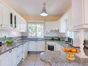 ネルハにあるVilla Villa Pueblo Jara by Interhomeのキッチン(白いキャビネット付)、カウンターにフルーツを用意しています。
