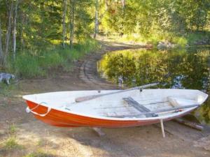 un barco sentado a un lado de un lago en Holiday Home Kettupirtti by Interhome, en Soiniemi