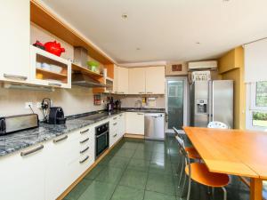 a kitchen with white cabinets and a wooden table at Villa Bertoni Golf & Sea by Interhome in Reus