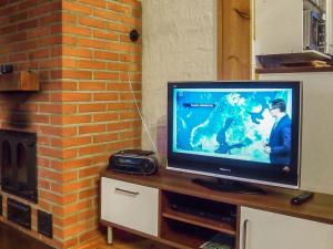 a flat screen tv sitting on a table next to a brick wall at Holiday Home Rantaheikari by Interhome in Torvoila