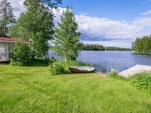 ein Boot auf dem Rasen neben einem See in der Unterkunft Holiday Home Kannashovi by Interhome in Taipale