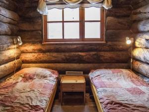 ein Schlafzimmer mit zwei Betten in einer Blockhütte in der Unterkunft Holiday Home Rukakolo by Interhome in Ruka + 14 Fotos