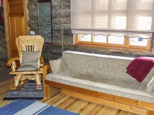 eine Couch in einem Zimmer mit einem Stuhl und einem Fenster in der Unterkunft Holiday Home Rukakolo by Interhome in Ruka