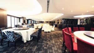 uma sala de jantar com mesas e cadeiras brancas em Grand Earl Hotel em Douliu