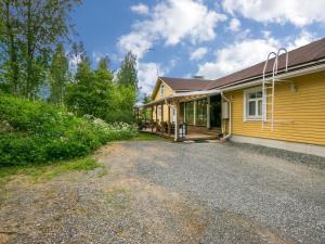 ein gelbes Haus mit einer Einfahrt davor in der Unterkunft Holiday Home Kannashovi by Interhome in Taipale