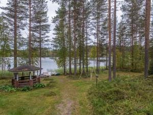 a gazebo in the woods next to a lake at Holiday Home Mäntyrinne by Interhome in Ruottila