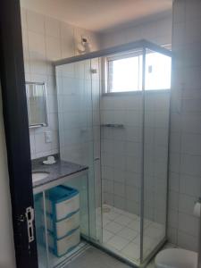 uma casa de banho com uma cabina de duche em vidro, um WC e um lavatório. em Residence Van Piaget em Fortaleza