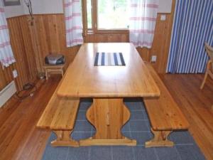 a wooden table with benches in a room at Holiday Home Kumpulahti by Interhome in Käylä