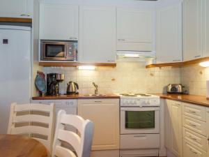 アカスロンポロにあるHoliday Home Kuerkartano 3-armas by Interhomeのキッチン(白い家電製品、テーブル、椅子付)