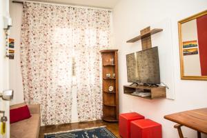 uma sala de estar com um sofá e uma televisão na parede em Apartamento Djalma Urich no Rio de Janeiro