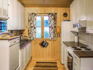 a kitchen with white cabinets and a window at Holiday Home Rantaheikari by Interhome in Torvoila